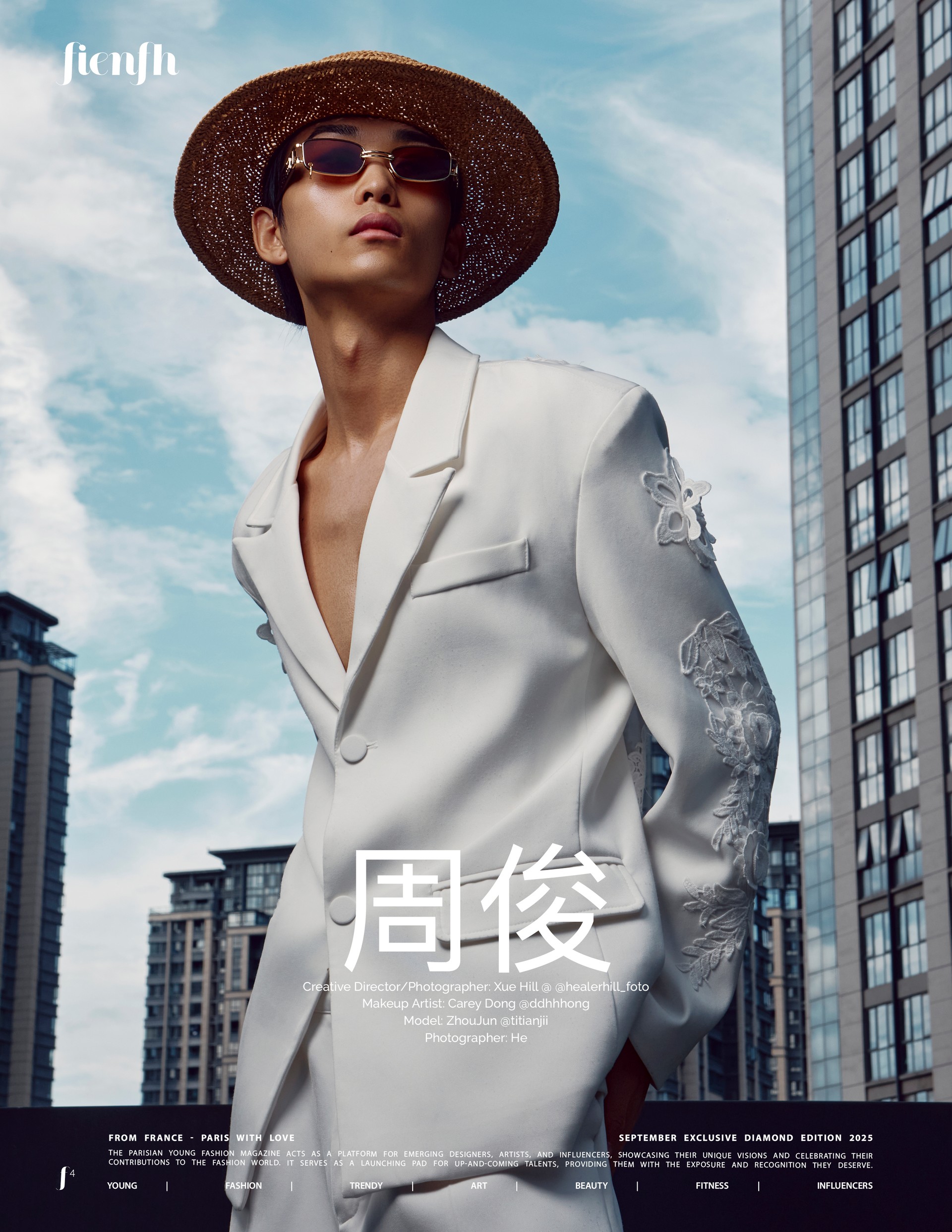 An editorial fashion portrait with a straw hat and white blazer against city buildings, in the original Fienfh magazine layout